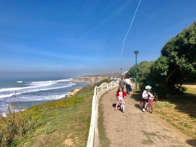 Children biking up on the cliff above Sao Sebastiao Beach