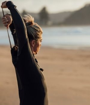 zipping up a wet suit at Ribeira D'Ilhas
