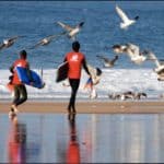body boarders going down to the beach with their boards.