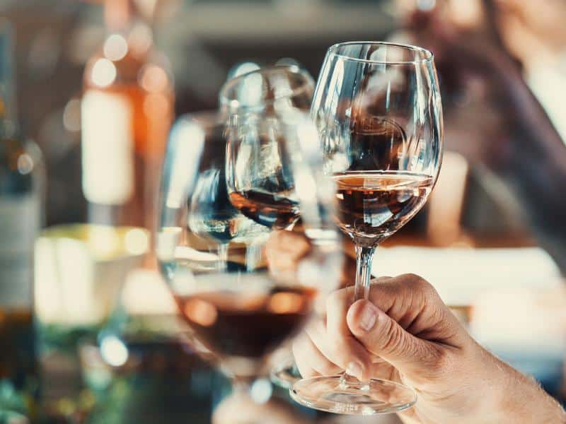 Three red wine glasses in a toast while doing a wine tasting in Ericeira.