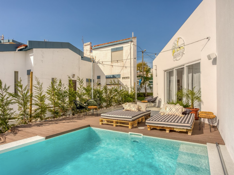 The beautiful pool area with lounge chairs and plants on the deck at Selina Boavista boutique hotel Ericeira.