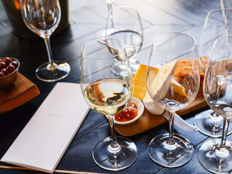 Four glasses of white wine with a board of tapas, Quinta da Santana has the best wine tasting in Ericeira.