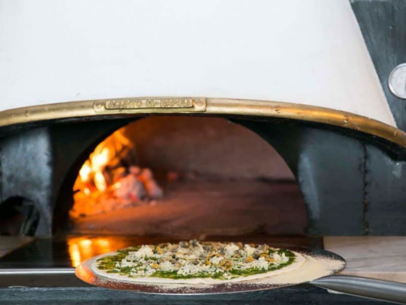 A pizza coming out of the oven at Jangada, the restaurant at You and the Sea Ericeira.
