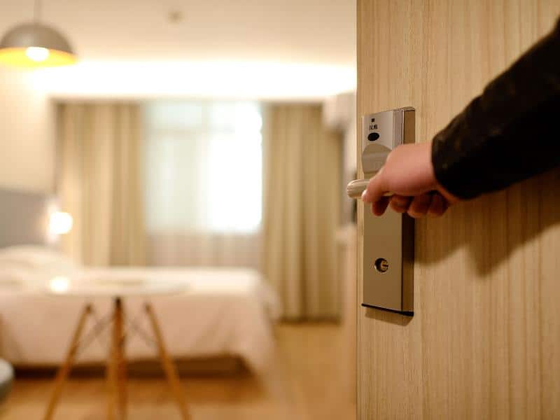Man opening a hotel room door.