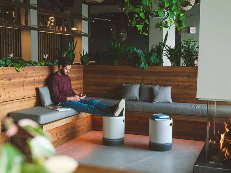 A man enjoying the fireplace in the restaurant lounge area at You and the Sea Ericeira