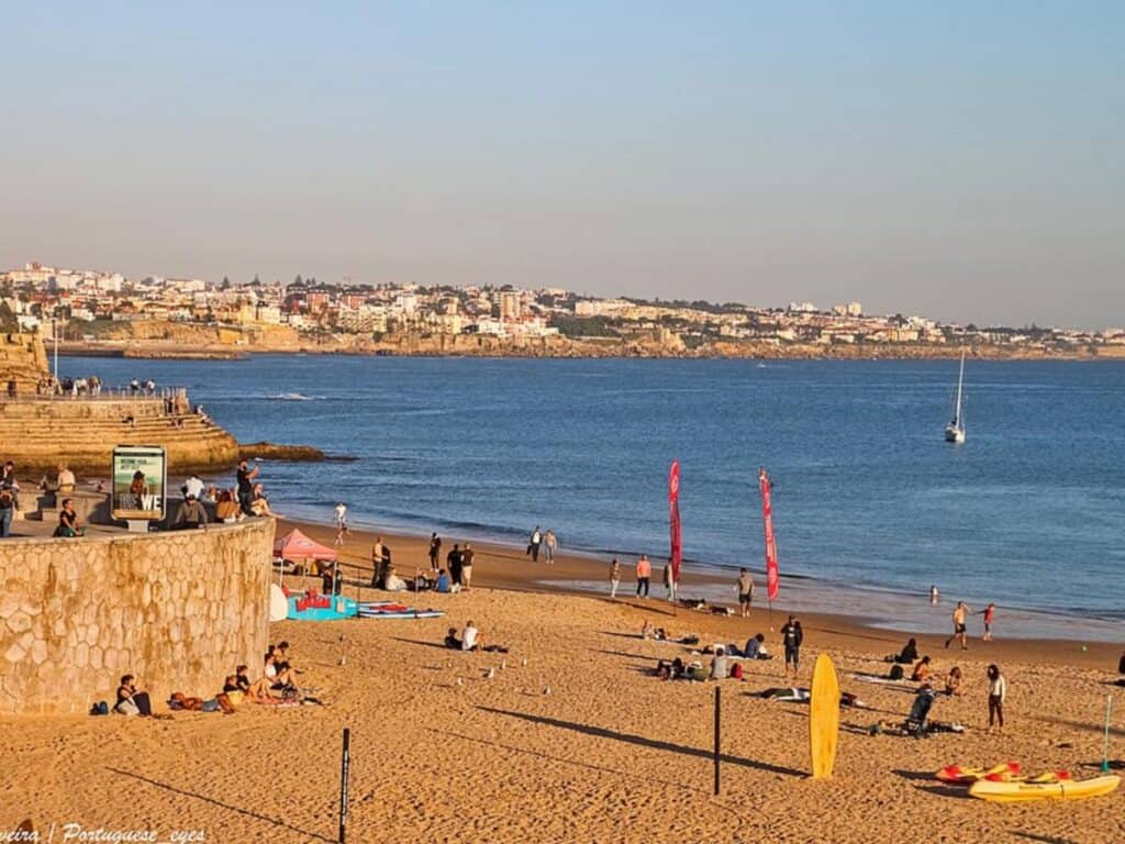 Praia da Duquesa with a hazy sky, long shadows on the afternoon beach.