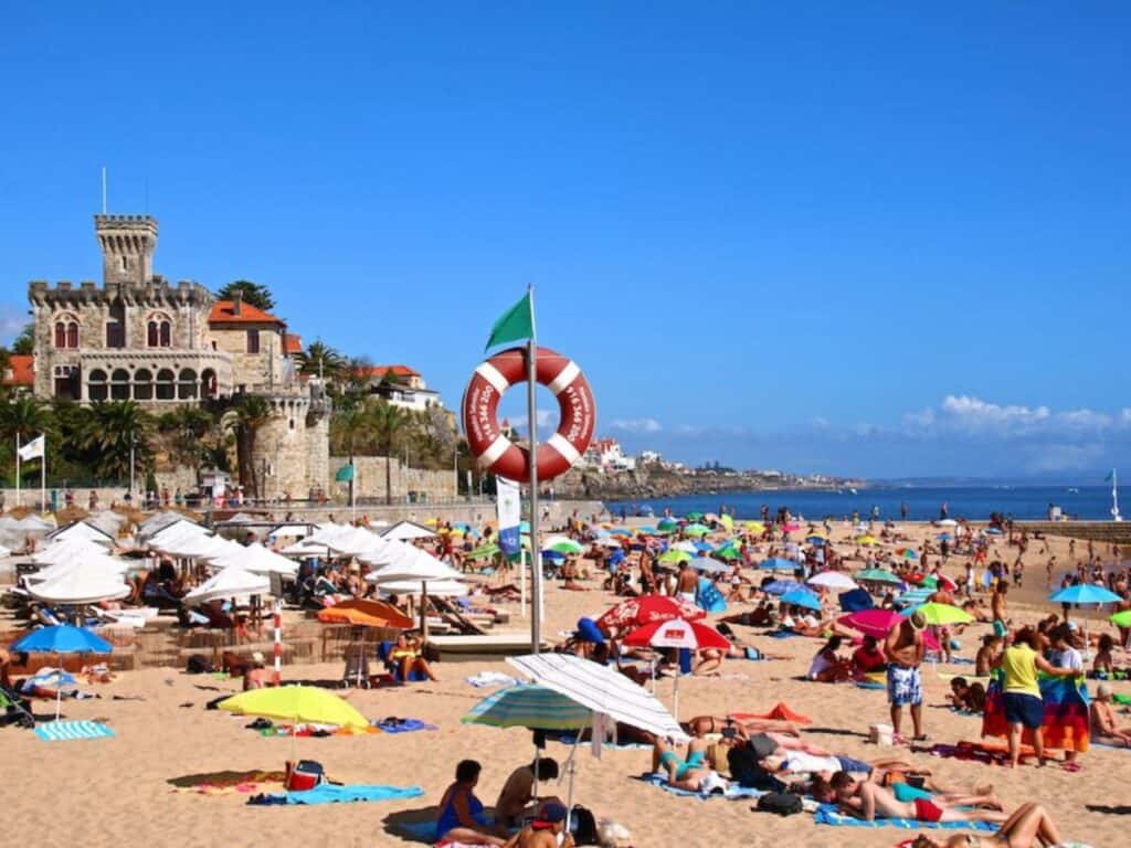 Jam packed Praia da Tamariz in August with its lovely palacete to the left on a beautiful sunny day.