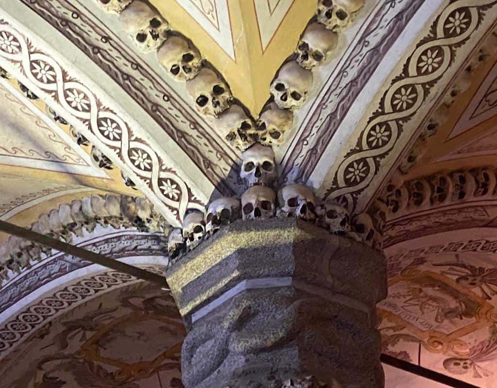 Detail of skulls used at the top of a pillar in the Cathedral dos Ossos. On the list of what to do in Evora Portugal, this is the most known because of the eerie collection of bones from 5000 monks used to decorate the interior.