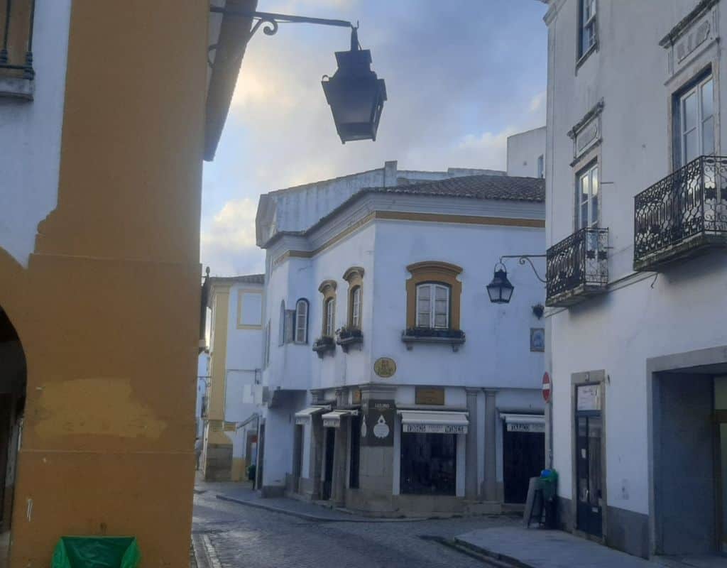 Evora's central street with quaint decorative touches like gas lanterns and wrought iron balconies and windows.
