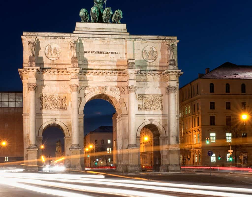 Cars speeding at night past the Munich Victory Gate. Munich is one of the most stressful cities for drivers in Europe.