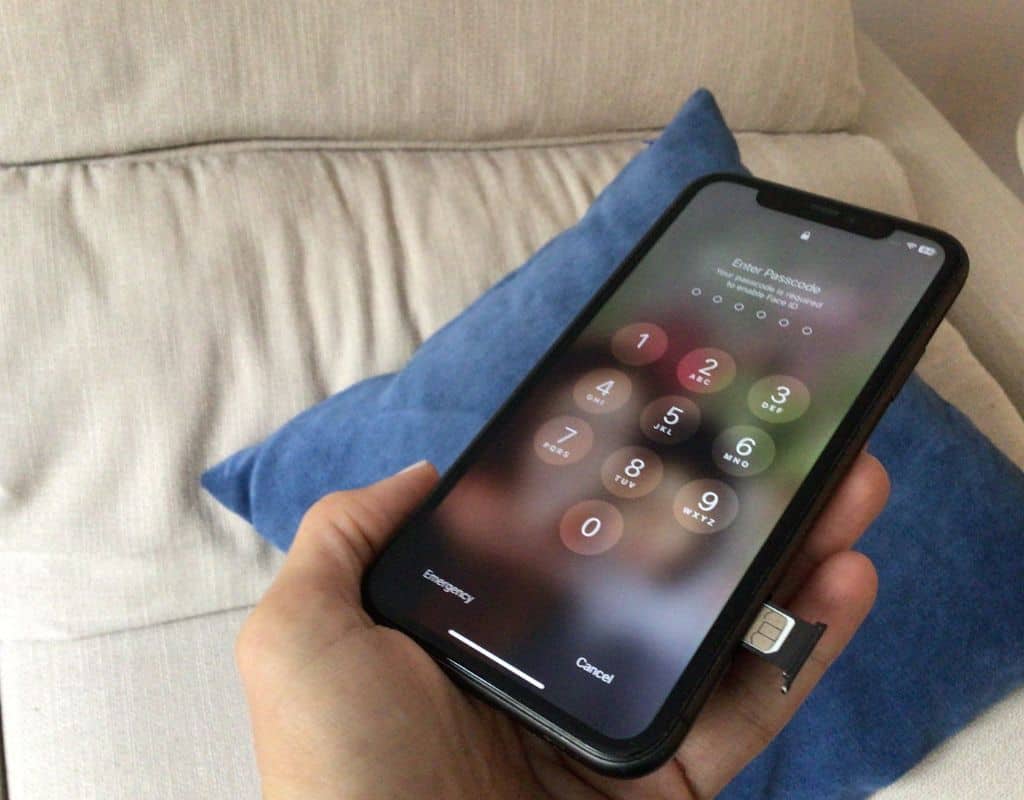 A smartphone with a SIM card tray partially ejected, showing the process of inserting or removing a SIM card.